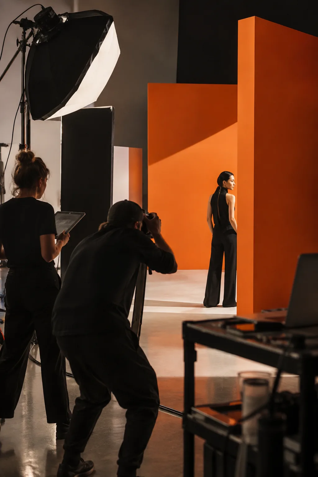 Campaign production team working on a geometric orange studio set